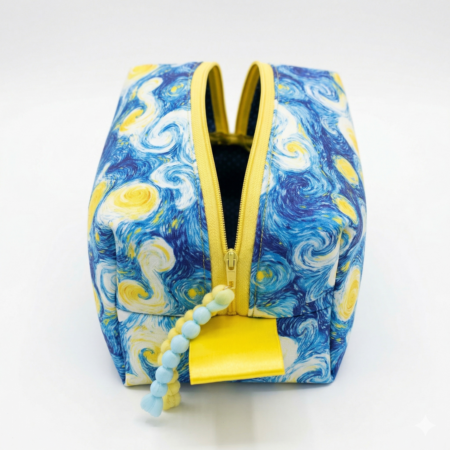 Neceser Noche Estrellada Van Gogh con diseño inspirado en la obra de arte, cremallera amarilla y detalles en tonos azules y amarillos vibrantes.