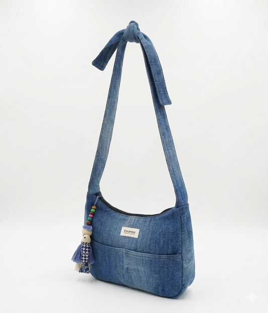Bolso Denim con Lazo y Borlas en tela jean azul con detalle de borlas y cuentas decorativas, correa anudada para un estilo casual y práctico.