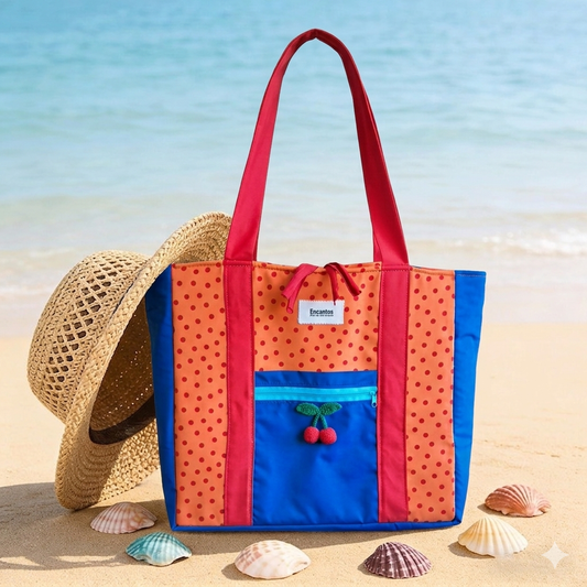 Bolsa Tote Cerezas — Encantos en colores vibrantes con detalles de cerezas, ideal para la playa o salidas casuales, junto a un sombrero de paja y conchas marinas.