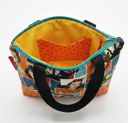 Interior del bolso pop art Encantos abierto mostrando forro amarillo con lunares y bolsillo interior naranja