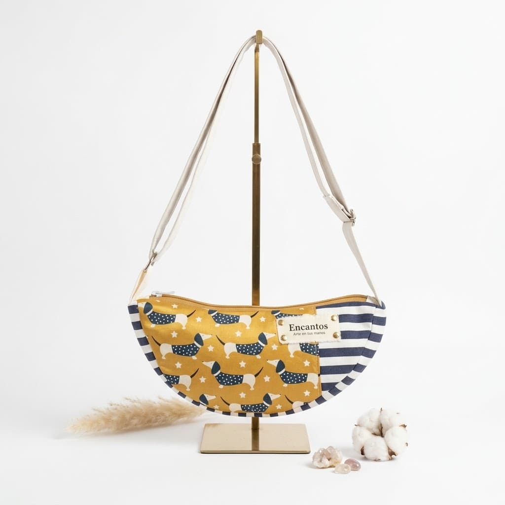 Bolso media luna con perritos salchicha mostaza, rayas navy y correa clara, vista frontal