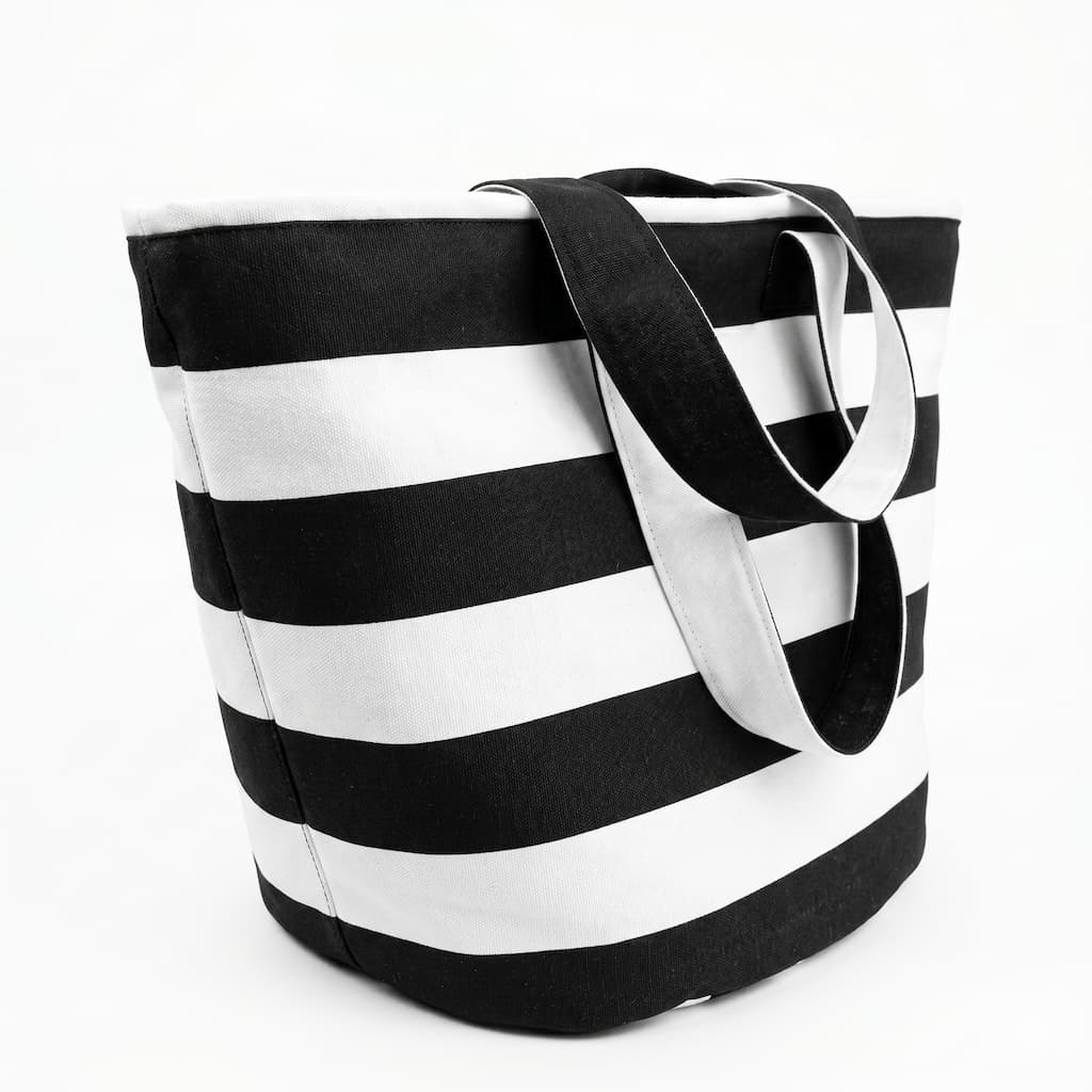 Vista lateral de la tote bag rayas blanco y negro mostrando la base reforzada y las asas