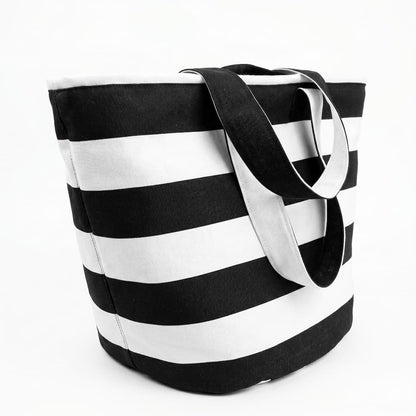 Vista lateral de la tote bag rayas blanco y negro mostrando la base reforzada y las asas