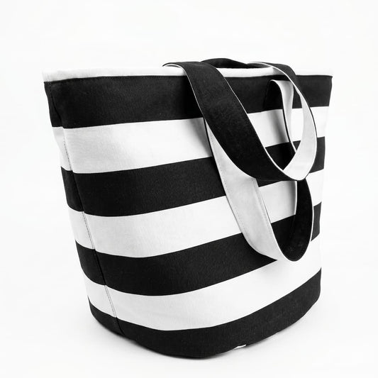 Vista lateral de la tote bag rayas blanco y negro mostrando la base reforzada y las asas