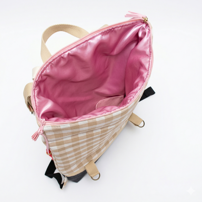Mochila Vichy Rosa | Encantos vista desde arriba, mostrando interior rosa brillante y diseño exterior a cuadros beige con correas ajustables.