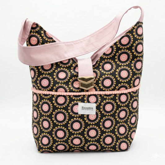 Bolso Hobo Círculos Rosa & Negro | Encantos con diseño circular en tonos rosa y negro, correa ancha rosa y detalle metálico decorativo en la parte frontal.
