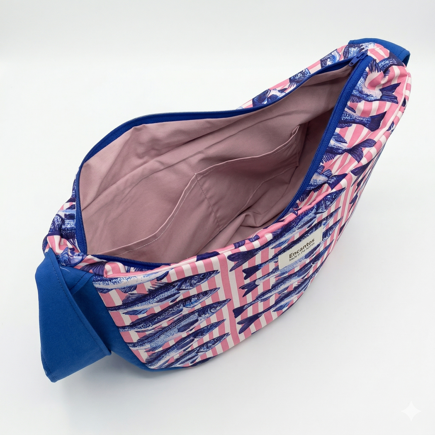 Bolsa Hobo Sardinas · Encantos con estampado de sardinas en tonos azul y rosa, forro interior color rosa claro y correa azul, abierta mostrando compartimentos internos.
