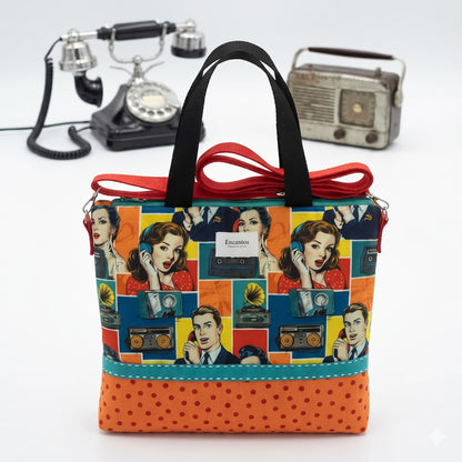 Bolso Colección Carolina pop art sobre mesa con teléfono vintage y radio retro de fondo