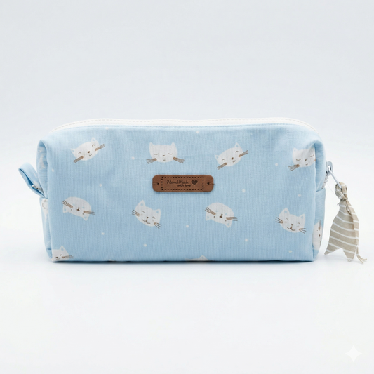 Neceser Gatitos Azul Cielo de tela con estampado de gatitos blancos y cierre blanco, diseño suave y práctico para uso diario.
