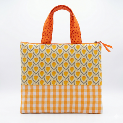 Bolso Tote Tulipanes con Volante de Lunares en tonos amarillos y naranjas, con diseño floral y cuadros, asas con estampado de lunares y cierre con cremallera.