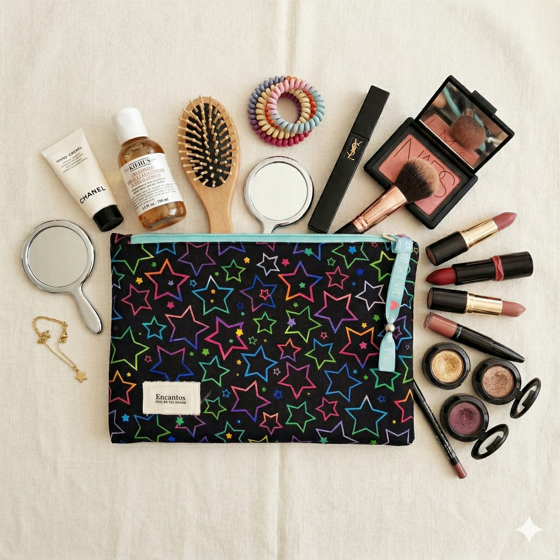 Neceser Estrellas Neon Negro | Encantos con diseño de estrellas de colores neón sobre fondo negro junto a productos y accesorios de belleza.
