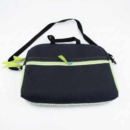 Bolso Laptop Vichy Verde de diseño sencillo en tonos oscuros con detalles en verde claro y cierre frontal, incluye asa y correa ajustable para mayor comodidad.