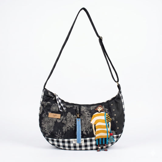 Bolso Luna Flores & Vichy Negro — Encantos con diseño floral negro, detalles a cuadros, y figura de mujer bordada en tonos amarillo, azul y rojo.