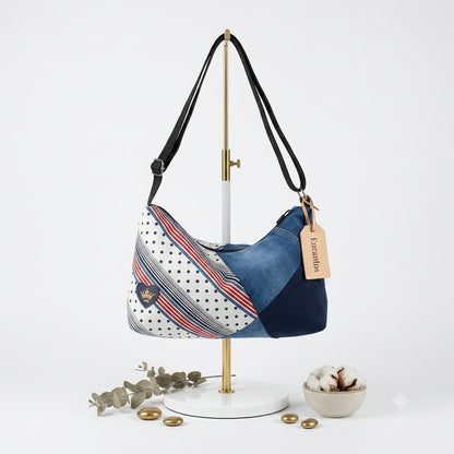 Bolso hobo patchwork denim y lunares, vista frontal en soporte dorado