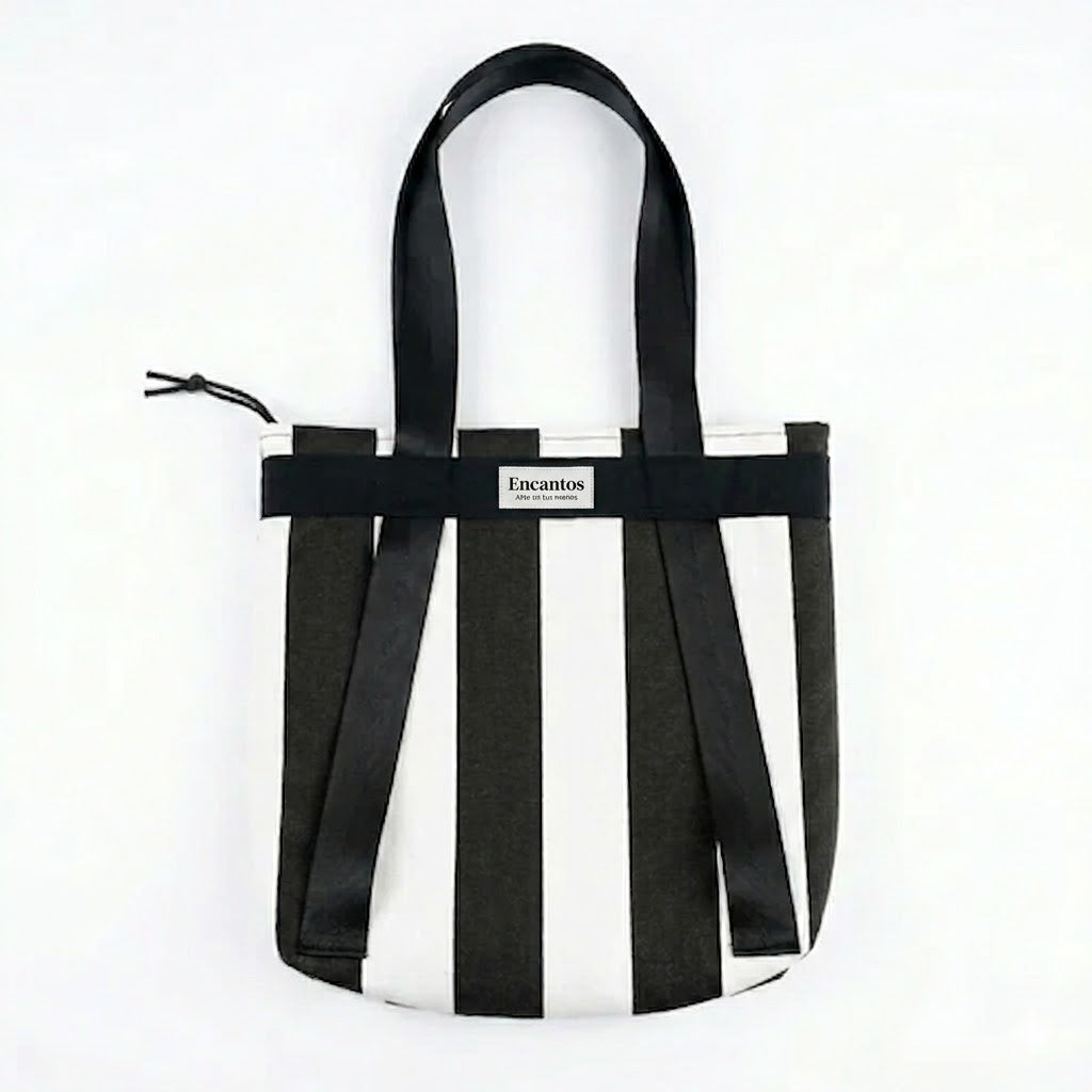 Bolso Tote Rayas Blanco y Negro 2 en 1 con diseño de rayas verticales en blanco y negro, asas largas y cierre superior con cordón para mayor seguridad.