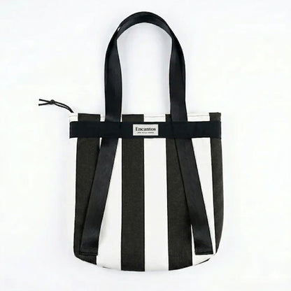 Bolso Tote Rayas Blanco y Negro 2 en 1 con diseño de rayas verticales en blanco y negro, asas largas y cierre superior con cordón para mayor seguridad.