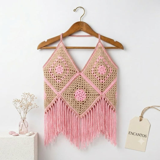 Top crochet rosa con flecos y motivos granny en percha con etiqueta Encantos, fondo blanco